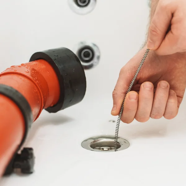 A picture showing a plumber cleaning a drain in Phoenix.